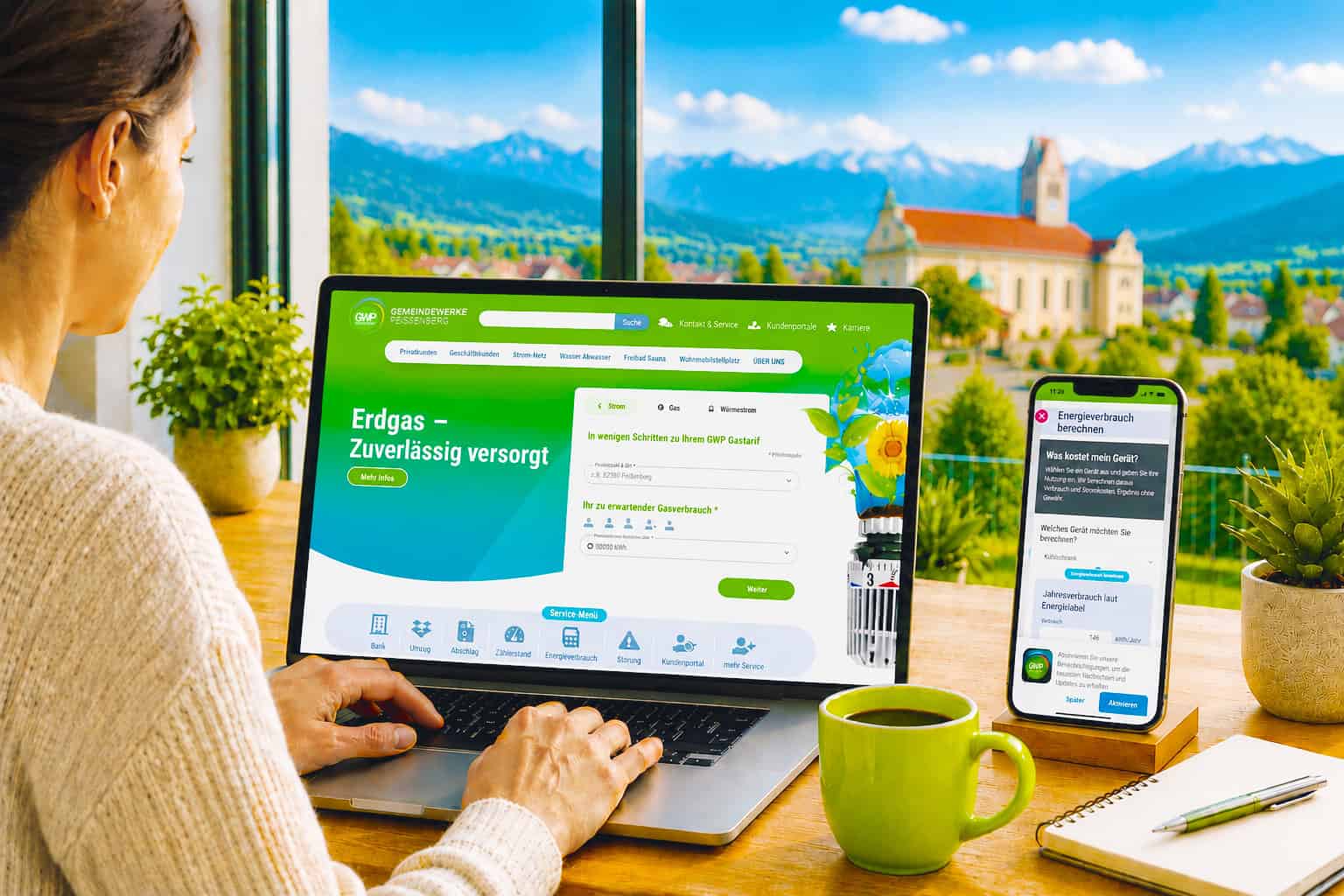 Person nutzt am Laptop die Website der Gemeindewerke Peißenberg, während auf einem Smartphone der Energieverbrauchsrechner angezeigt wird.