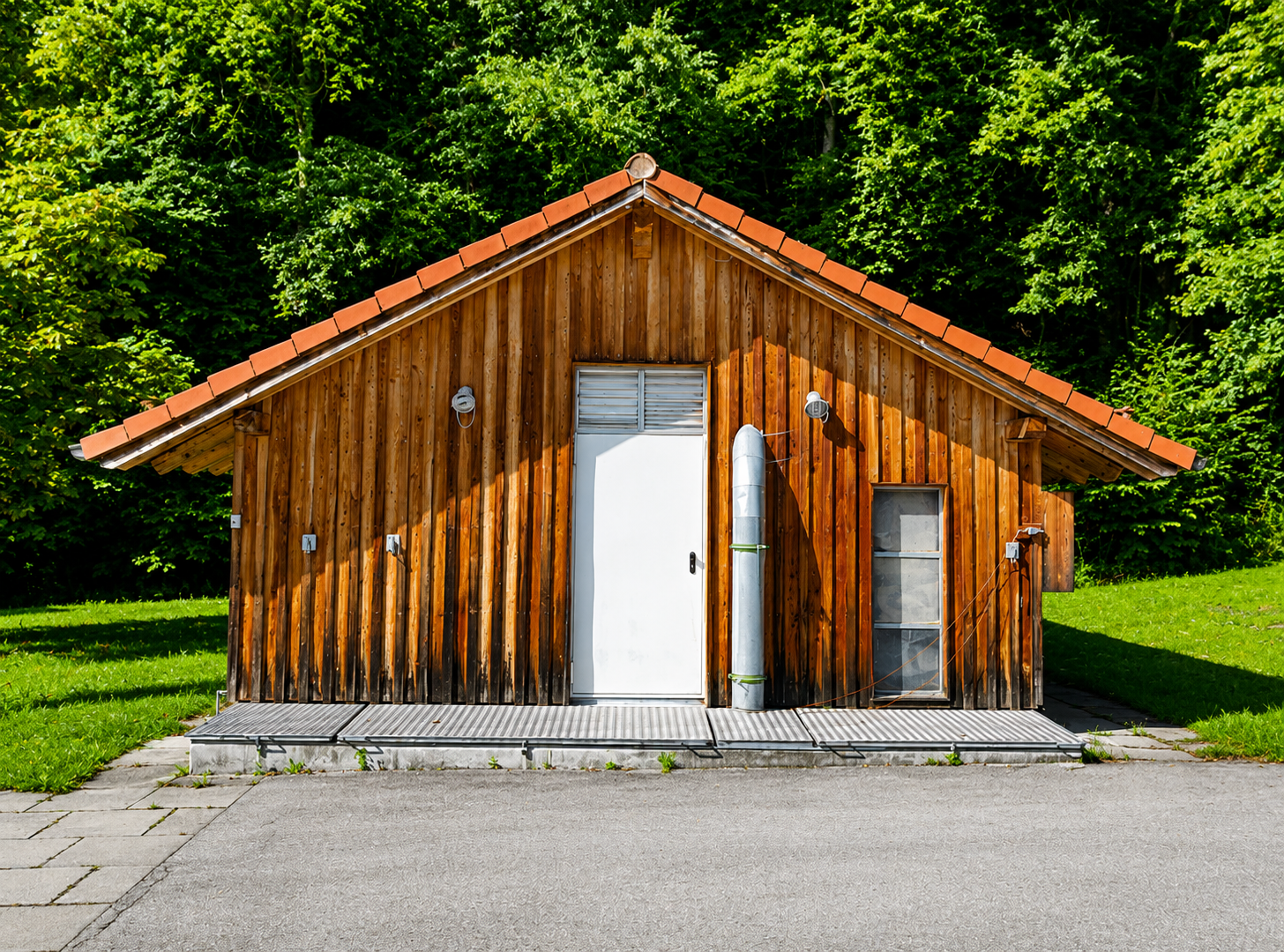 Technikgebäude einer Wärmeversorgungsanlage in naturnaher Umgebung.