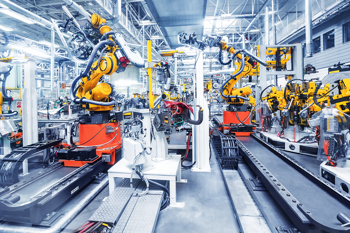 Moderne Produktionsanlage mit automatisierten Fertigungsrobotern in einer Industriehalle.